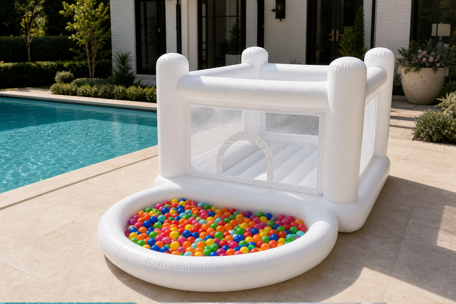 White Bouncy Castle and included multicolor ball pit beside a swimming pool